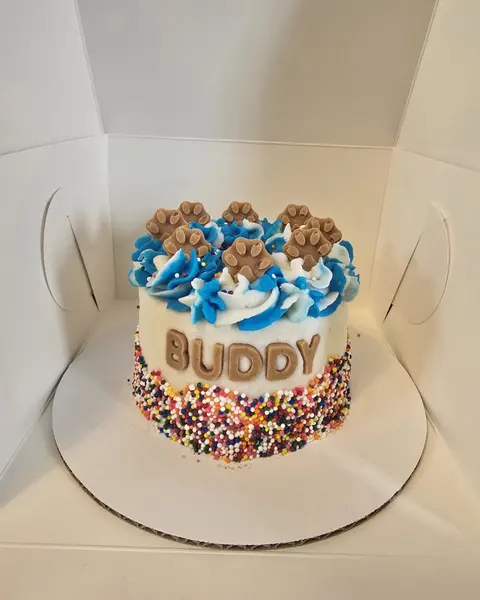 Small blue and white birthday cake with BUDDY piped on it