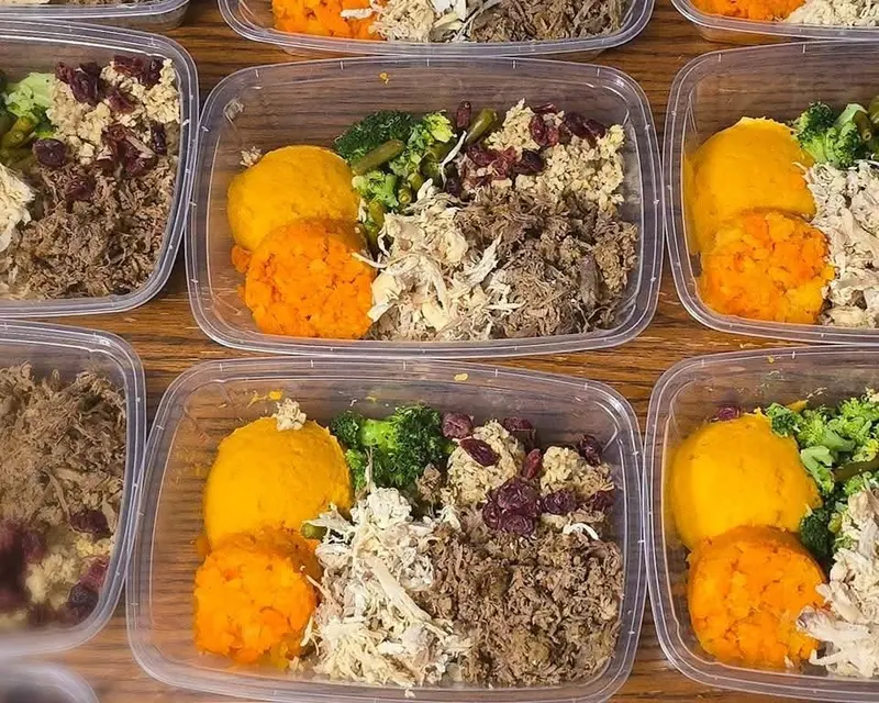 Dog dinner containers with shredded meat, sweet potato and broccoli