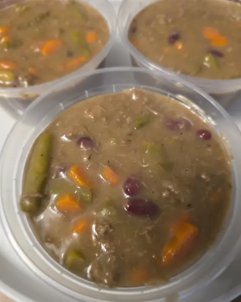 Tubs of beef stew for dogs with carrots, green beans and beans