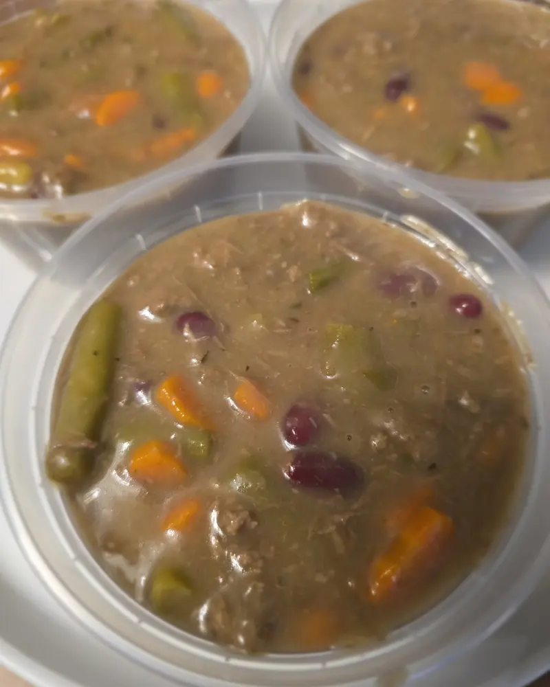 Tubs of beef stew for dogs with carrots, green beans and beans